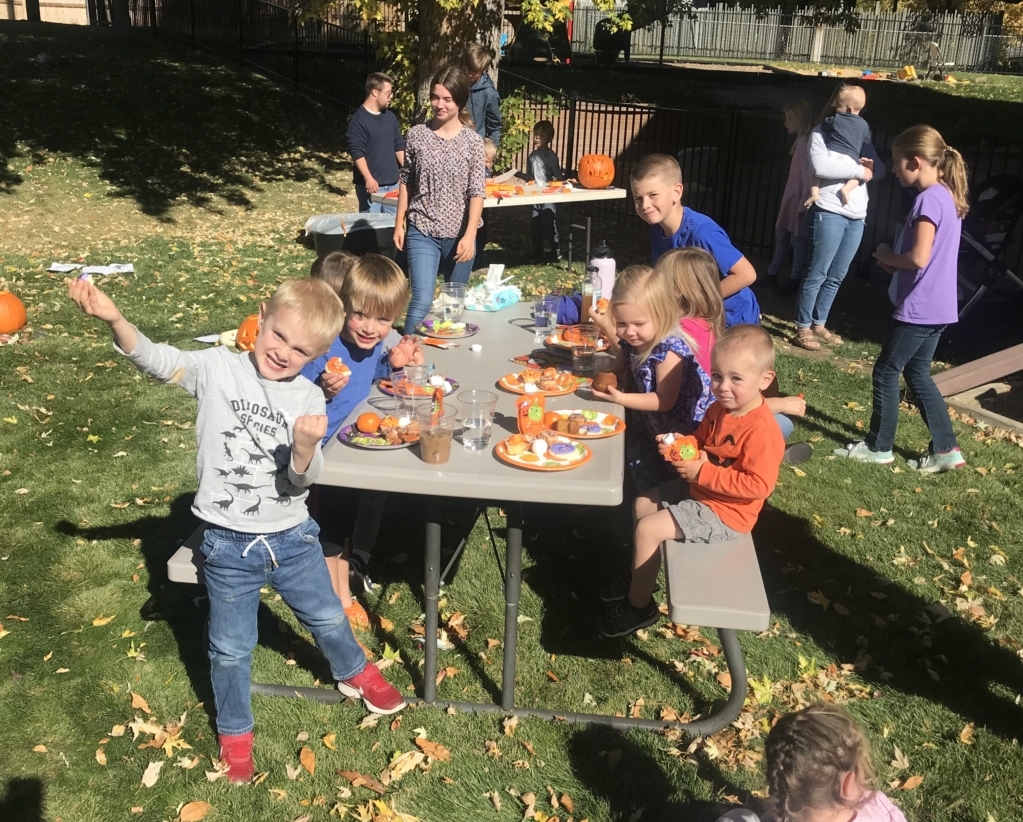 Homeschool children enjoying carving pumpkins